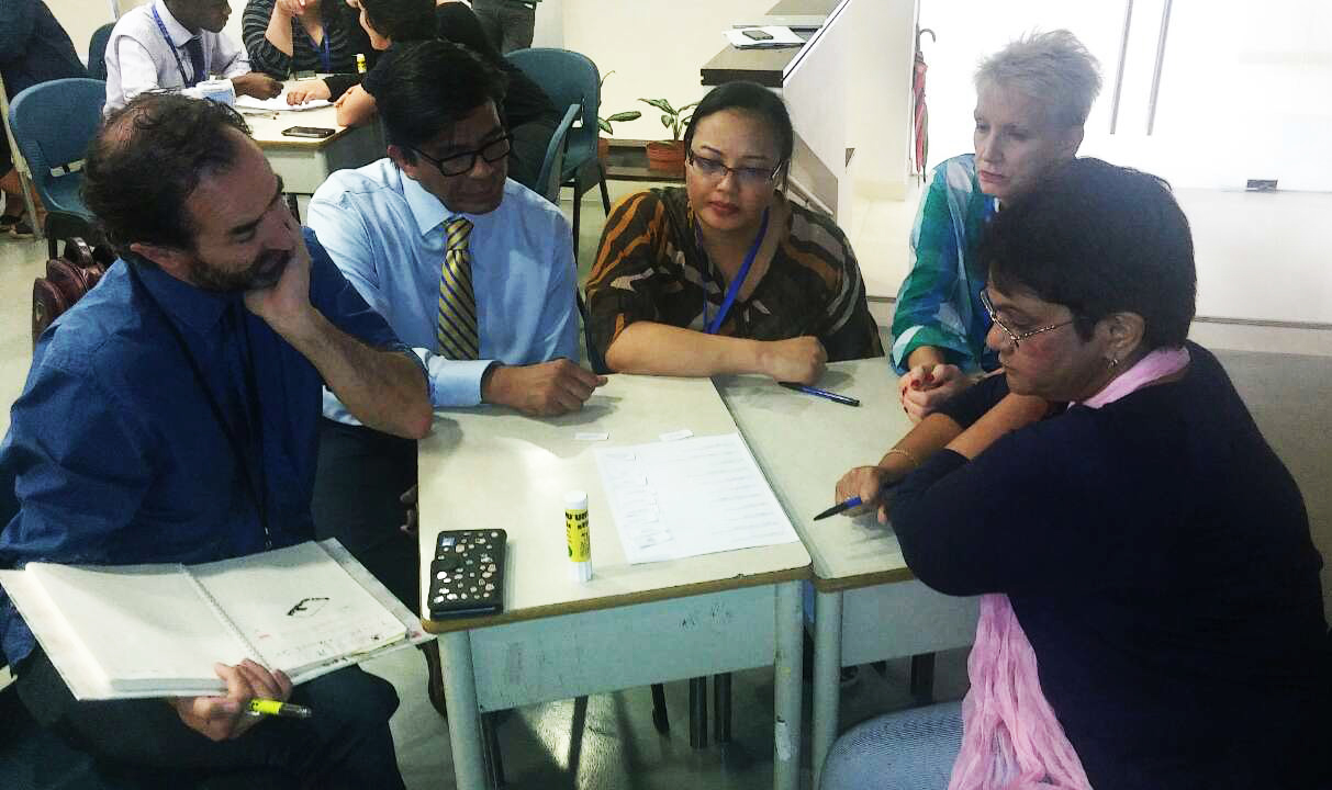 معلمین در حال آماده‌سازی یکی از دروس در بستر برنامۀ «انجمن آموزش حرفه‌ای» Professeional Learning Community هستند. معلمین در گروه‌های کوچک به صورت هفتگی با هم ملاقات می‌کنند تا با یکدیگر در زمینۀ تلاش‌هایشان مطالعه، تأمل و مشورت کنند.