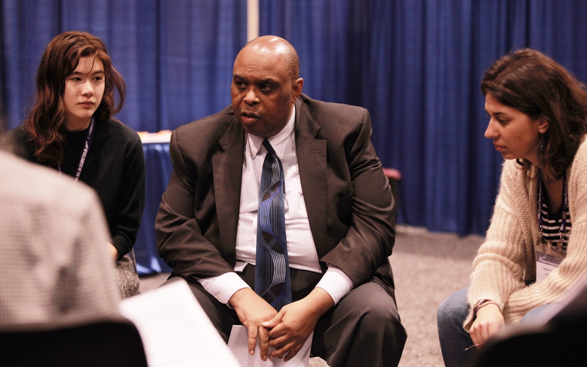 Carl Murrell (center) from the Baha’i Office of Public Affairs of the United States participates in a group discussion during the Parliament of the World’s Religions, held in November in Toronto, Canada.