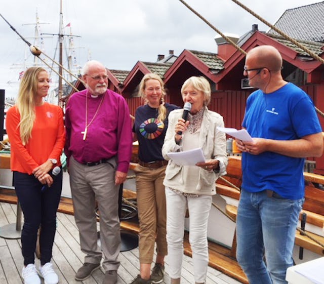 Britt Strandlie Thoresen (segunda desde la derecha), presidenta del Consejo para las comunidades religiosas y filosóficas de Noruega(en inglés), habla junto a otros cinco panelistas en una importante reunión nacional anual en la ciudad de Arendal. El evento reúne a líderes gubernamentales, la sociedad civil y las comunidades religiosas para discutir los principales problemas que afectan al país. Aquí, la Sra. Thoresen habla en un panel sobre el medio ambiente. El evento, que se llamó La Catedral de la esperanza, se llevó a cabo sobre el agua para resaltar la contaminación de los océanos y otros problemas ambientales.