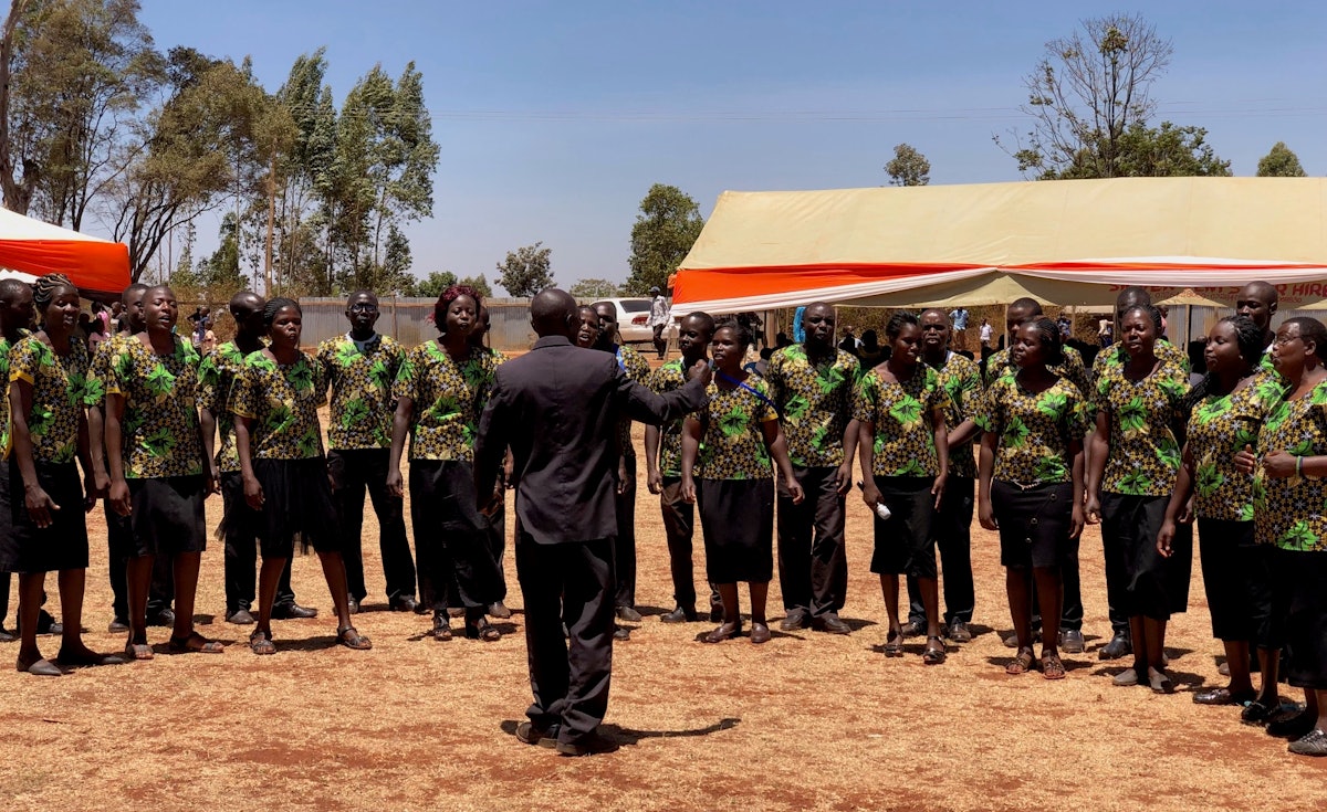 La chorale de la communauté hôte lwanda, chante lors de la cérémonie pour marquer le début de la construction du temple Matunda Soy.