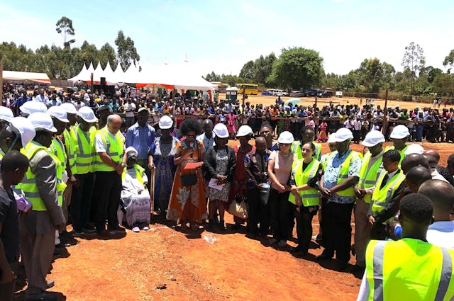 Ruth Vuyiya, sentada, una creyente bahá'í local conocida cariñosamente como Mama Ruth, colocó la primera piedra dando inicio a la primera Casa de Adoración local bahá'í en África el sábado en Matunda, Kenia. En esta foto se la ve con su hija, miembros de la Asamblea Espiritual Nacional de Kenia, contratistas de la construcción y la arquitecta del templo Neda Samimi.