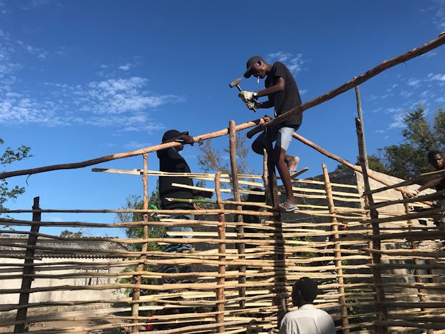 Two young Baha’is Frederico Coutinho (top center) and Elisha Antonio (left) traveled from other communities in the Beira Corridor of Mozambique to assist the Dondo’s recovery from Cyclone Idai. Here they join other young people in rebuilding the home for a resident of Dondo.