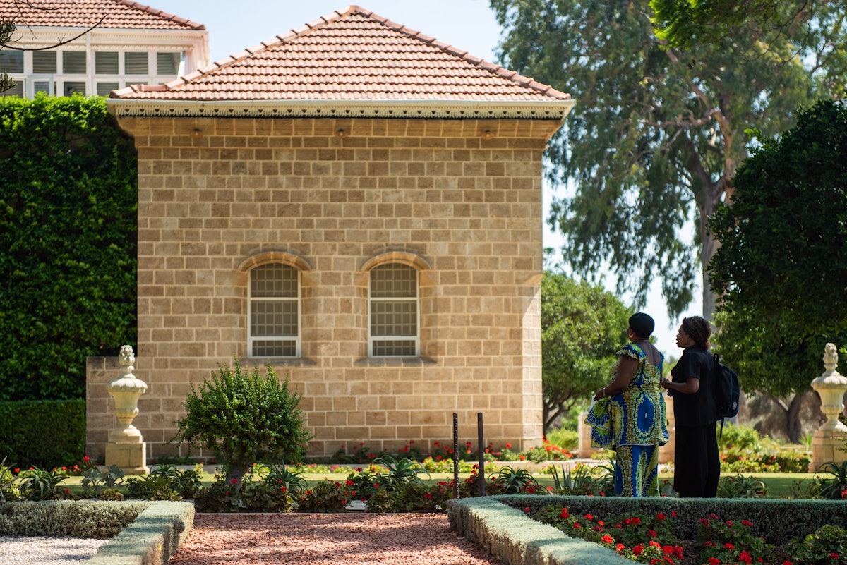 Dos peregrinos rezan en el exterior del Santuario de Bahá’u’lláh.