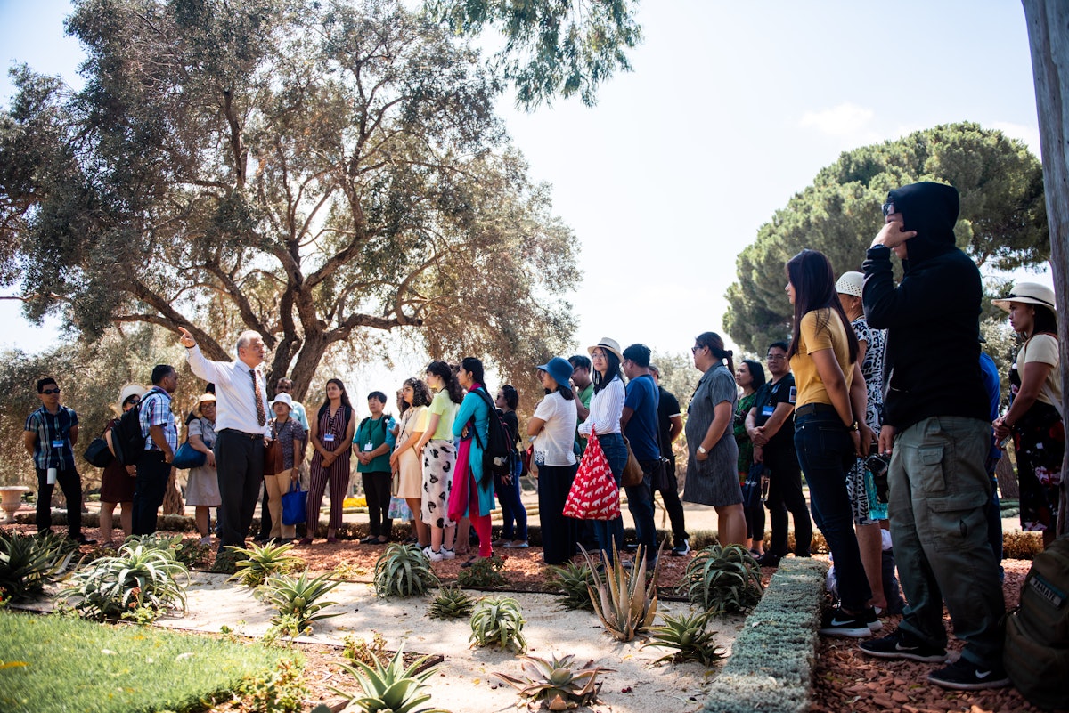 Un guía habla con un grupo de peregrinos de Austria, Camboya, Estados Unidos, Filipinas, India y otros países durante su visita a la Mansión de Bahjí, donde Bahá’u’lláh vivió los últimos 12 años de Su vida.