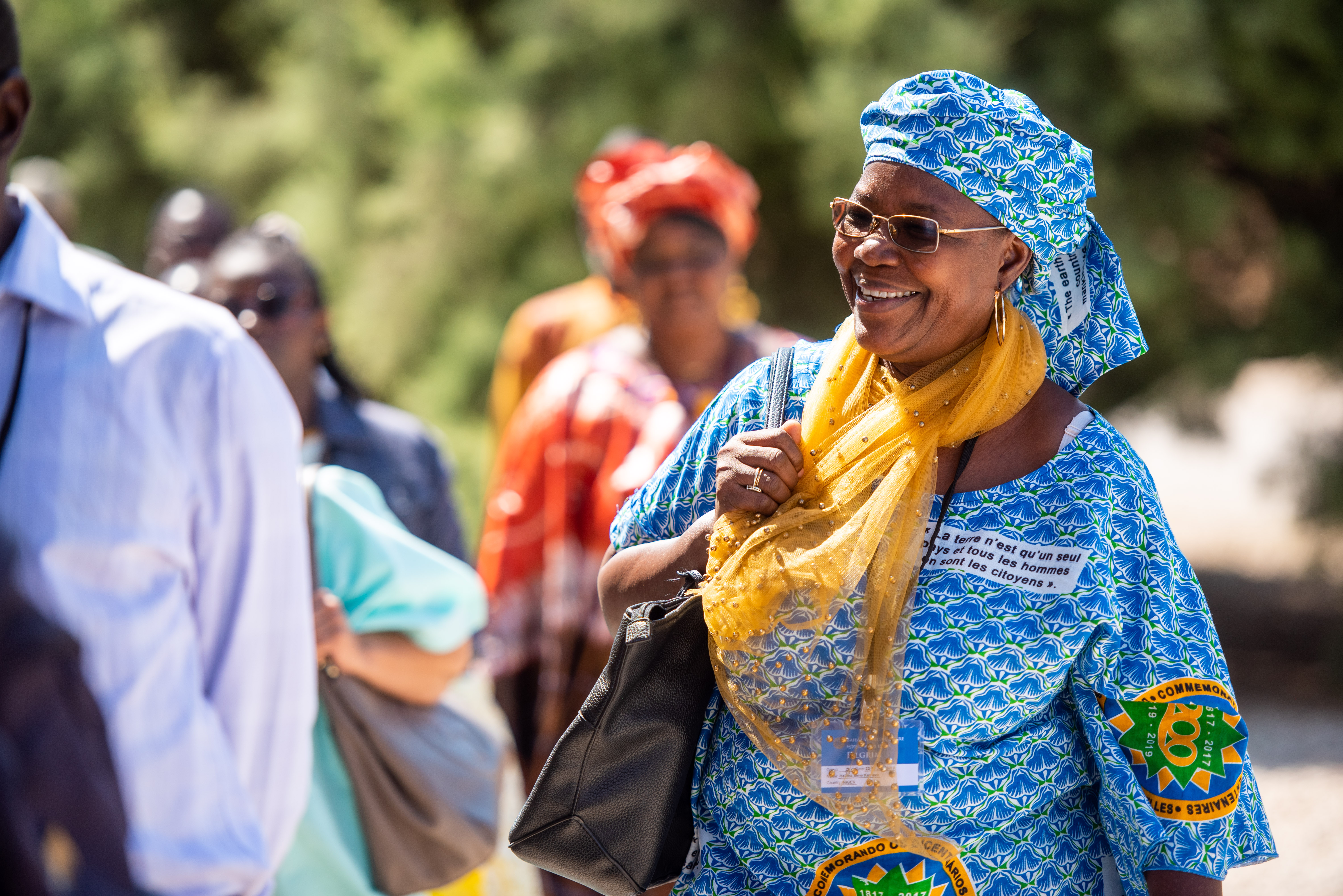 یکی از زائران از جمهوری دموکراتیک کنگو در حالی که  لباس مخصوصی که به مناسبت دویستمین سالگرد تولد حضرت بهاءالله طراحی شده است را بر تن دارد به همراه گروهش از خانهٔ عبدالله پاشا بازدید می‌نماید.