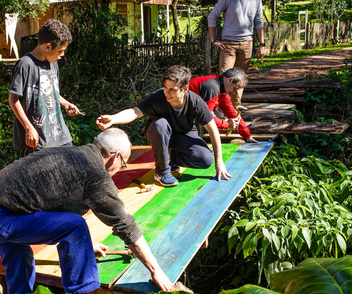 Jóvenes y adultos reparan un puente de uso frecuente en Sapucaia, Brasil: una de otras tantas iniciativas.