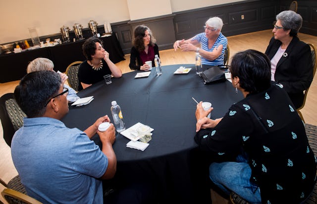 Speakers and attendees converse during a break at the recent Baha’i Chair conference about the equality of women and men.