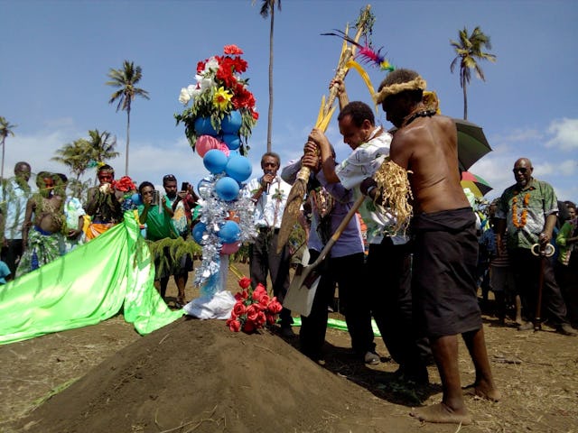 Foreign Minister Ralph Regenvanu and President of the Malvatumauri National Council of Chiefs Willie Plasua together drive the kakel—a traditional wooden spade—into the soil, symbolizing the start of construction on the local Baha’i House of Worship on the island of Tanna, Vanuatu.