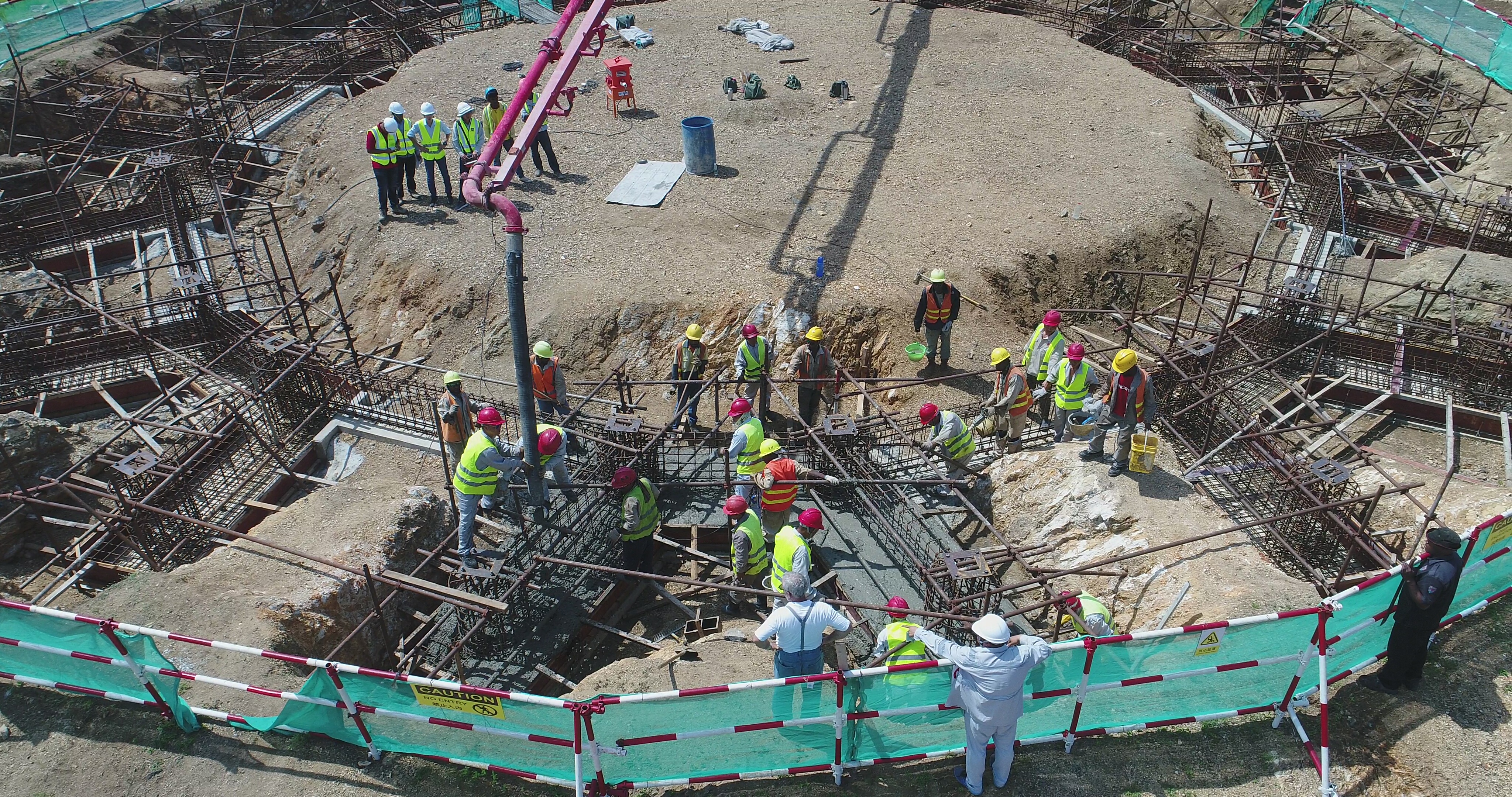 A concrete boom pump stretches across the 34-meter-wide Temple site to pour concrete for the Temple’s foundation.