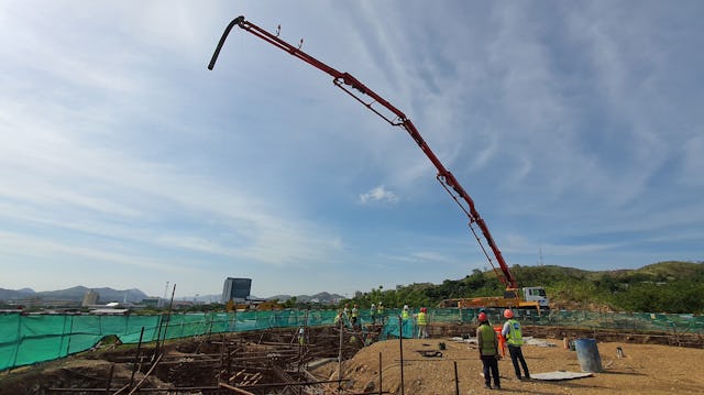 La pompe à béton s’élève haut dans le ciel.