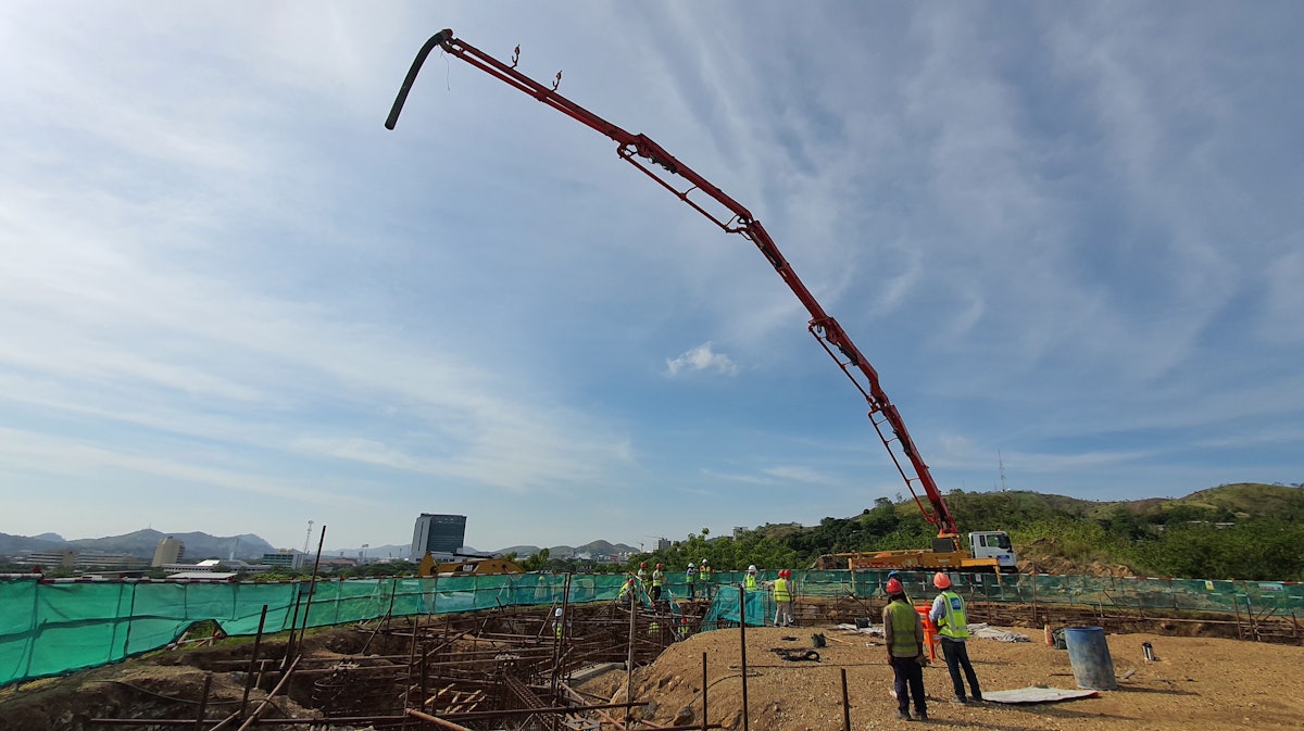 The concrete boom pump stretches high in the sky.