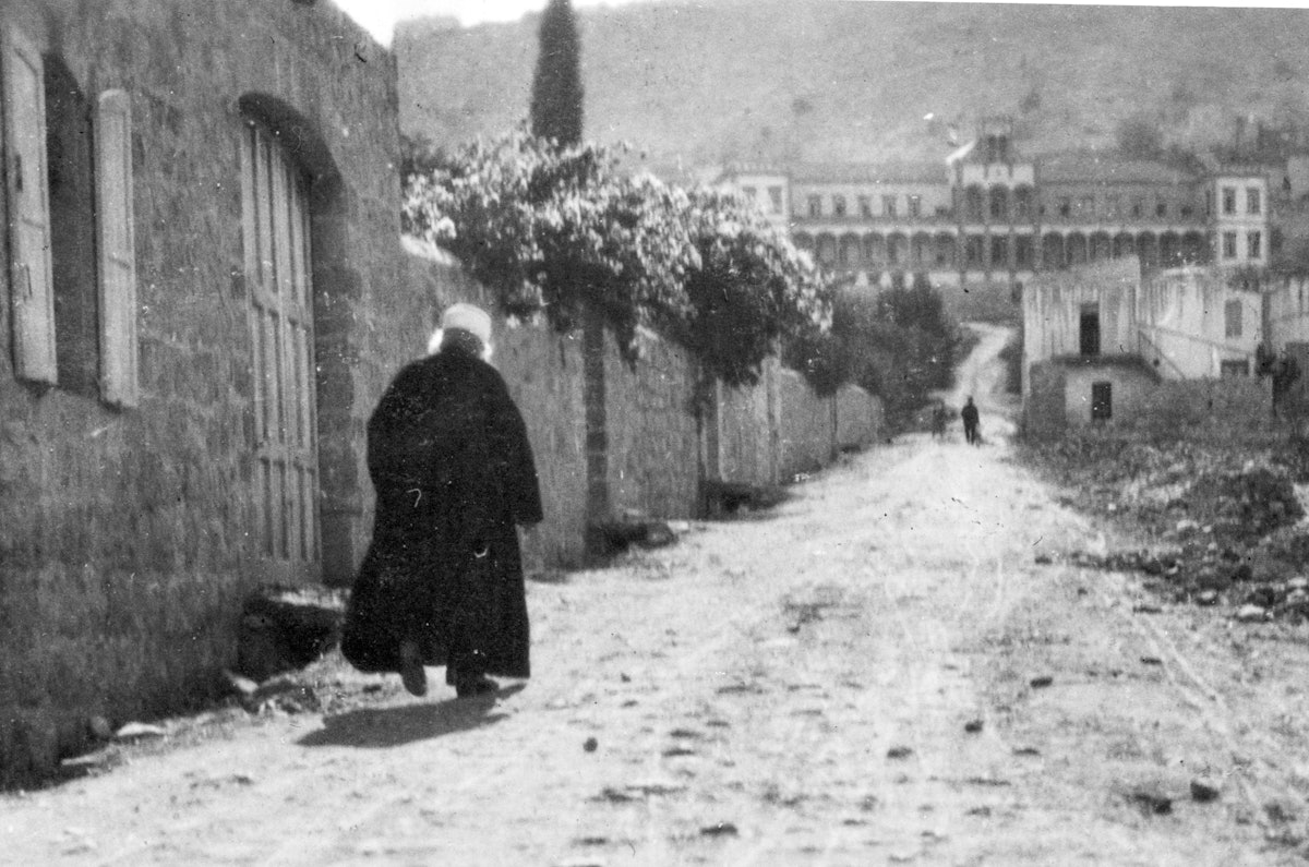 Photo de ‘Abdu’l-Bahá, marchant devant son domicile de la rue Haparsim à Haïfa en 1920, la même année où la première Tablette à La Haye a été transmise à l’Organisation centrale pour une paix durable.