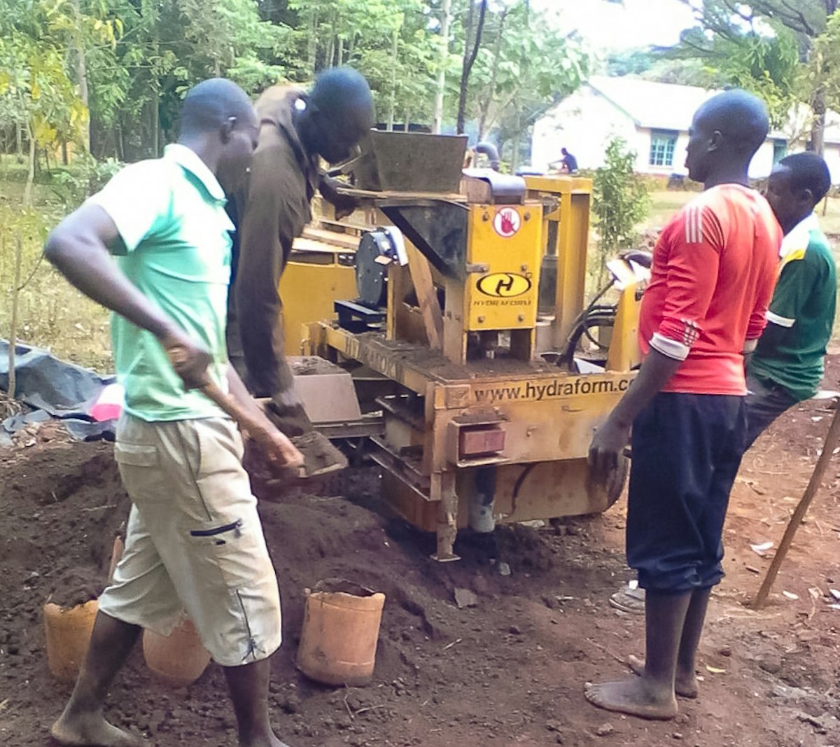 Le projet de construction d’un établissement d’enseignement à Namawanga a utilisé une machine hydraulique qui presse les briques constituées principalement de terre du site. La machine produit des briques emboitables qui sont simples à assembler sans avoir besoin de mortier.
