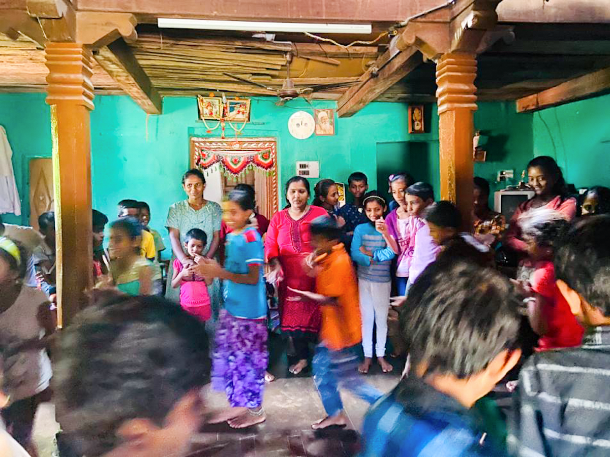 Photograph taken before the current global health crisis. Children and parents in Bookanakere, India, participating in a festival prepared by participants of Baha’i educational programs in the village.
