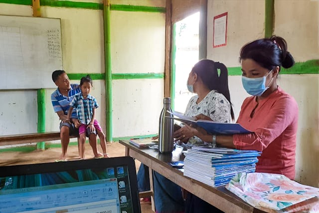 Par mesure de précaution pendant la crise sanitaire, les enseignants d’une école communautaire de Langathel, Manipur, en Inde, distribuent des travaux scolaires aux parents pour qu’ils les fassent avec leurs enfants à la maison.