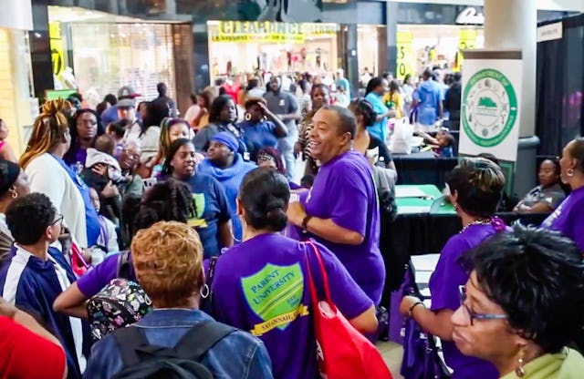 این عکس پیش از بحران سلامت فعلی گرفته شده است. دانشگاه پرنت برنامههای آموزشیای ارائه میدهد که برای والدین و معلمین این امکان را فراهم میکند که بهطور منظم در مورد مسائل پیش روی جامعه مشورت کنند. اغلب مدیران مدرسه و مقامات دولت محلی نیز در این مشورتها مشارکت دارند.