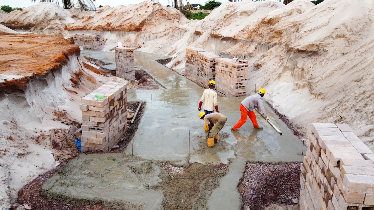 A process known as concrete blinding creates a smooth surface to work on. Masonry blocks are then used to create formwork for the reinforced concrete foundations.