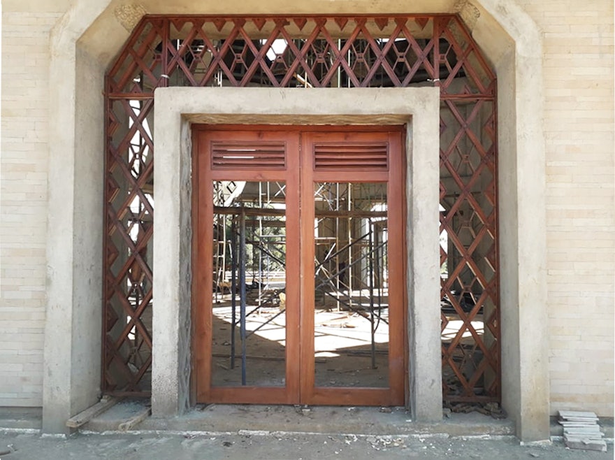 Une des neuf entrées de l’édifice central. Le treillis autour de chaque porte incorporera du verre entre les croisillons en bois. Le plâtre décoratif pour les colonnes extérieures et les portes est terminé.