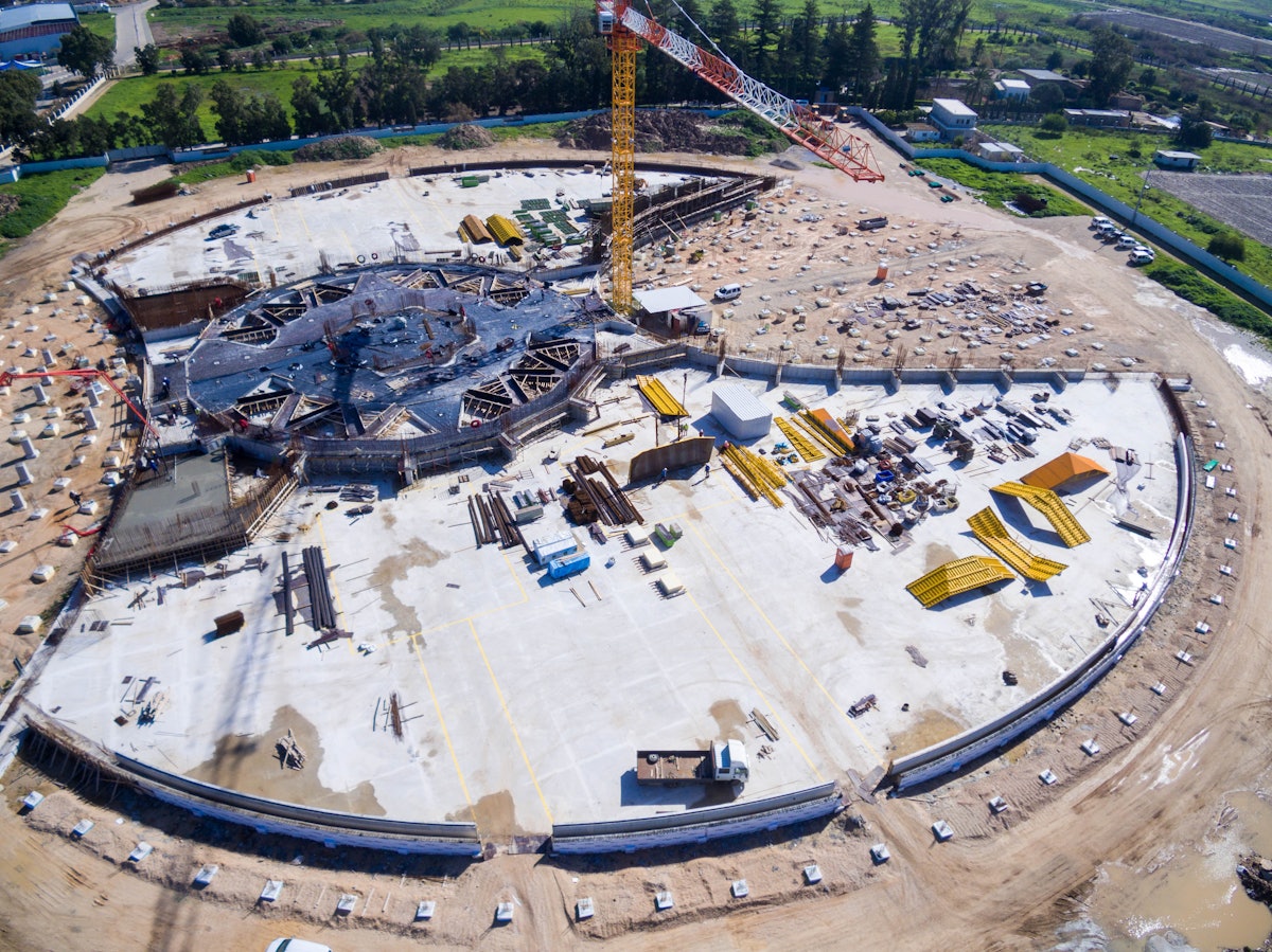 Sur cette vue aérienne du site de construction vu de l’ouest, les bases en béton achevées des deux talus du jardin révèlent le contour du mausolée. Visible au milieu du site se trouve le coffrage où le béton sera coulé pour le sol de la place centrale.