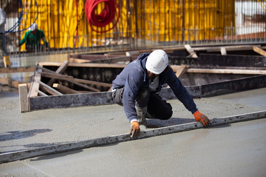 La surface en béton de la dalle de plancher est lissée après le coulage.