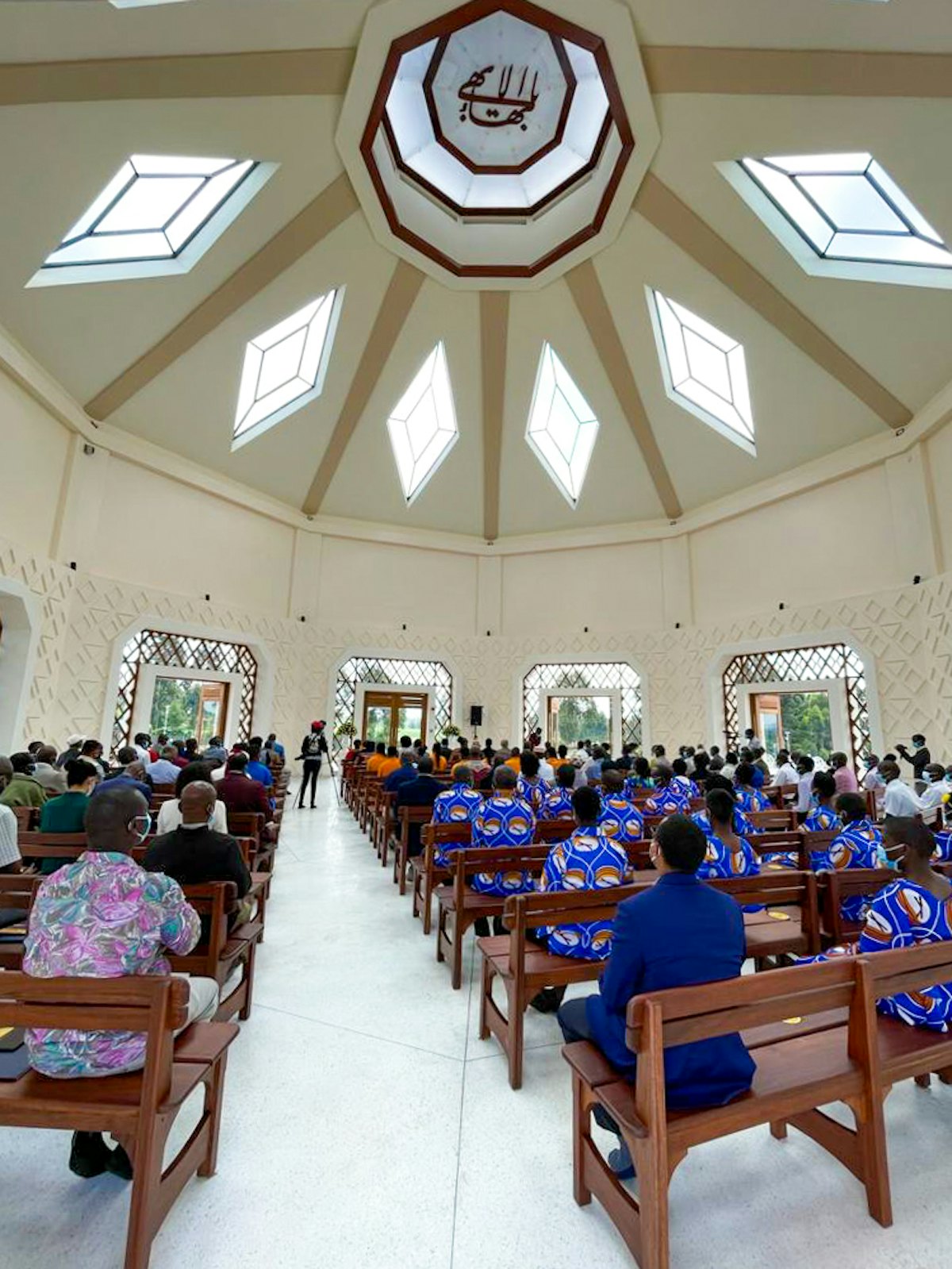 Los asistentes a la ceremonia de inauguración sentados en el interior del edificio central del templo durante un programa inaugural de oraciones.