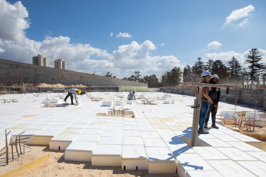 Before the concrete base of the south plaza can be built, “void former” blocks need to be fitted to separate the concrete platform from the soil.