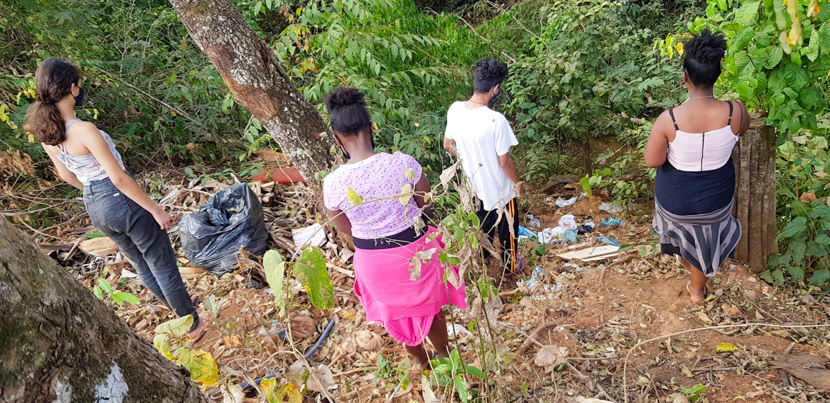 Some youth from the Vila do Boa neighborhood picking up litter around a local river.