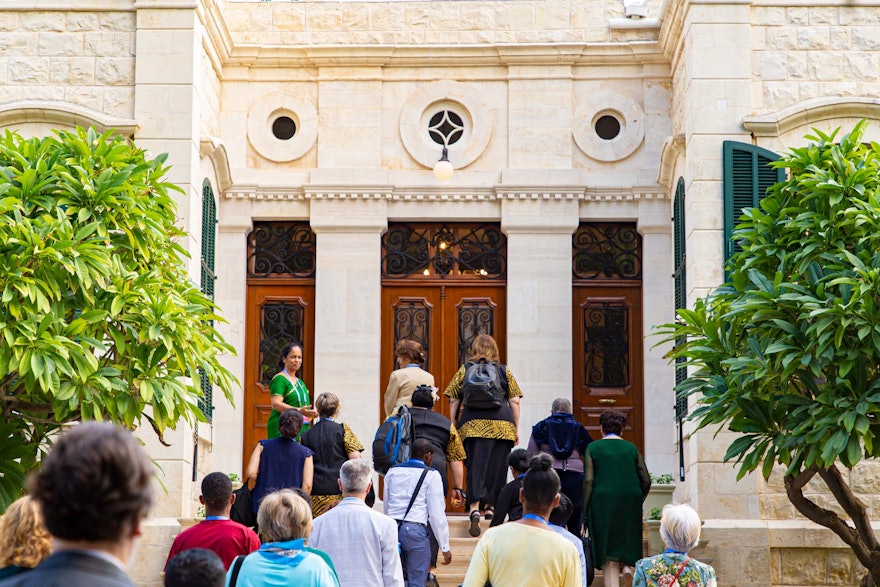 Un grupo de participantes aproximándose a la entrada de la casa de ‘Abdu’l-Bahá.