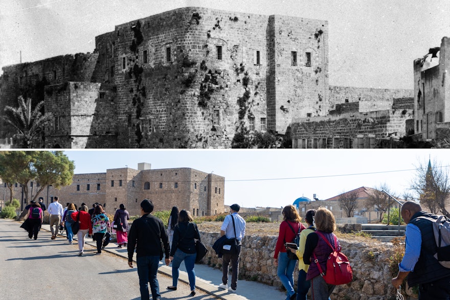 Les participants s’approchent de la citadelle où Bahá’u’lláh et sa famille ont été emprisonnés pendant plus de deux ans après leur arrivée à Acre en août 1868. Pendant cette période, ‘Abdu’l-Bahá a soigné les malades et s’est chargé du bien-être de leurs compagnons. L’image en haut présente une vue historique de la prison en 1907.