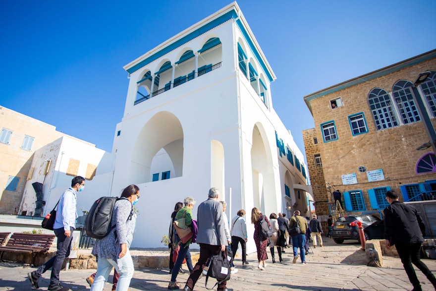 شرکت‌کنندگان در حال بازدید از بیت عبود، جایی که حضرت بهاءالله و خانواده‌شان، پس از ورود به این مکان در سال ۱۸۷۱ به عنوان تبعیدی و در حصر خانگی در فضای بسیار کوچکی زندگی می‌کردند.