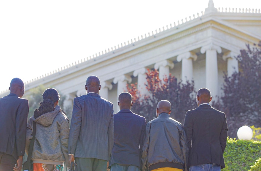 Un groupe de participants fait une pause pour méditer juste avant leur visite aux Archives internationales bahá’íes, qui contiennent des artefacts et des reliques directement associées à la vie des figures centrales de la foi bahá’íe.