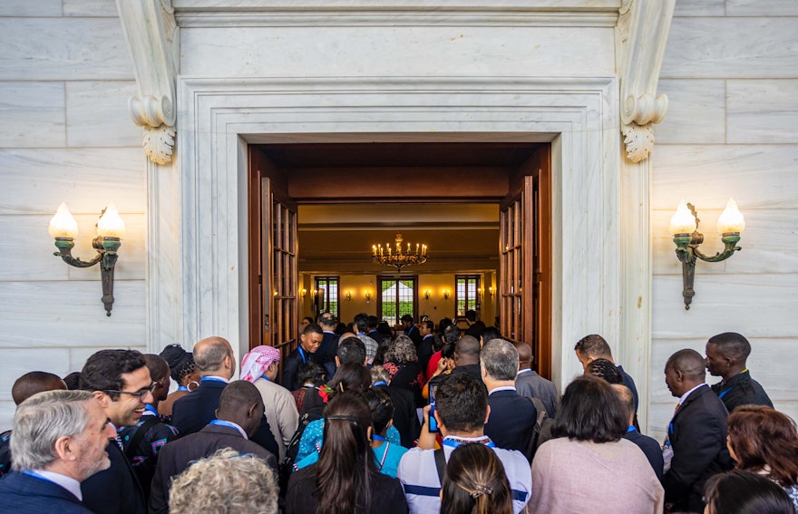 Los participantes accediendo al salón de recepciones de la Sede de la Casa Universal de Justicia.