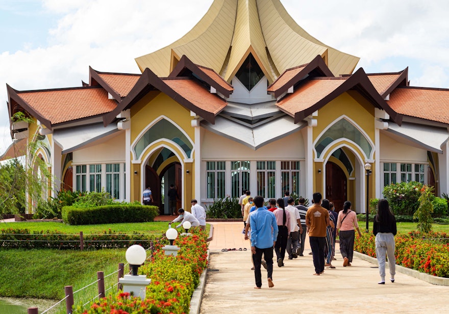 Residentes de la zona llegando a la Casa de la Adoración de Battambang para el programa de la tarde con motivo del centenario.