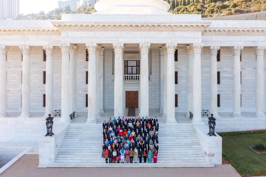 Aerial photo of the Counsellors on the steps of the Seat of the Universal House of Justice