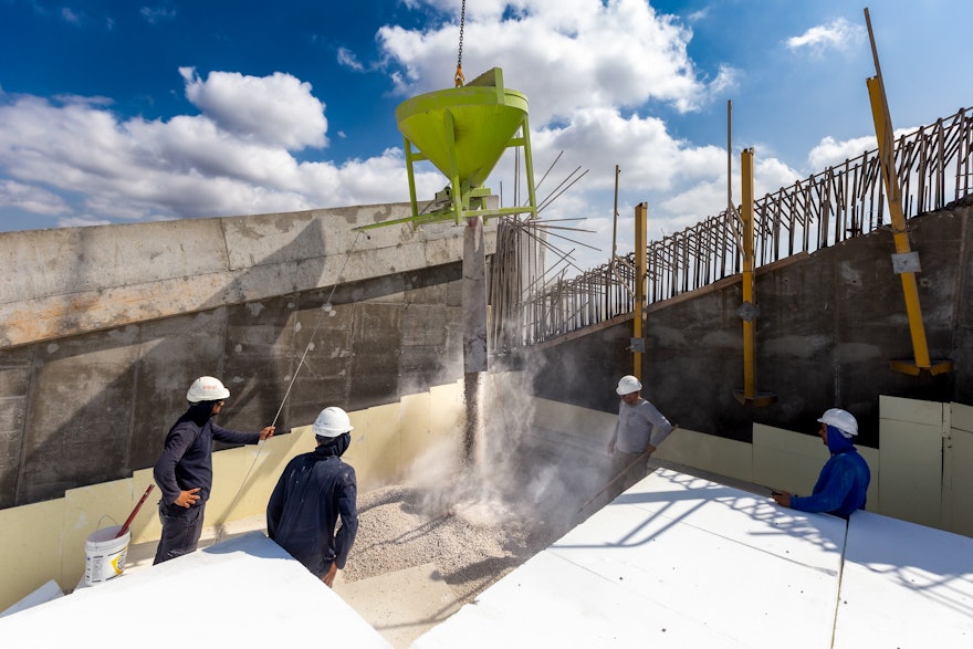 Gravel is poured onto the formwork using a crane.