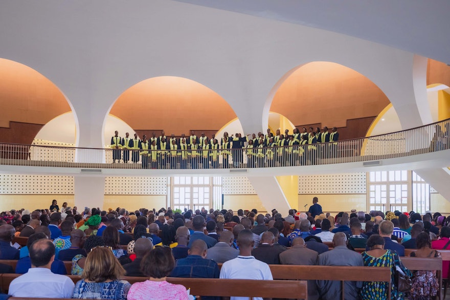 Un coro entona una oración musicada durante el programa religioso en el interior del edificio central.