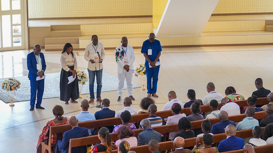 Participants sit inside the House of Worship for its first devotional program consisting of prayers and Bahá’í writings.