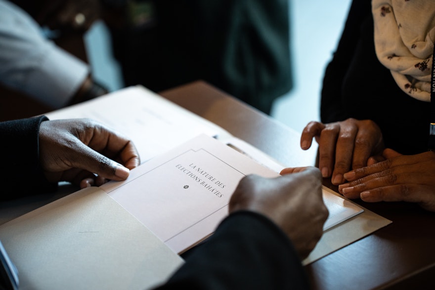 Une participante reçoit un ensemble de documents lors de son inscription.