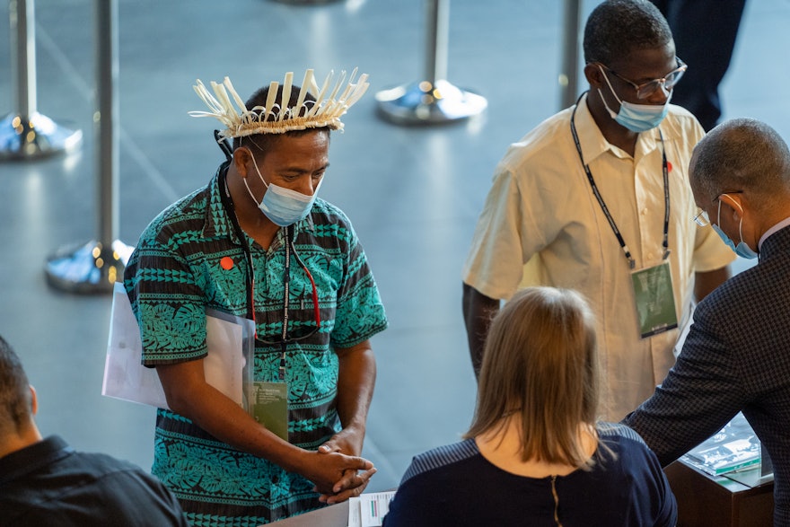 A delegate from Kiribati (left) registers for the International Convention.