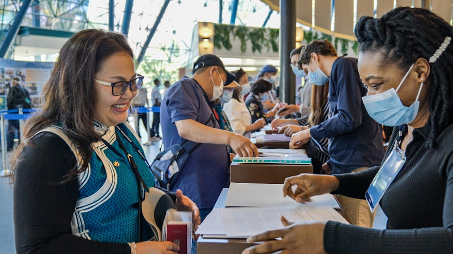 A delegate from Mongolia is assisted throughout the registration process.