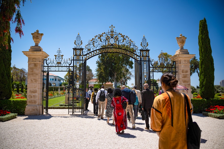 Délégués franchissant la porte Collins pour se rendre au tombeau de Bahá’u’lláh.