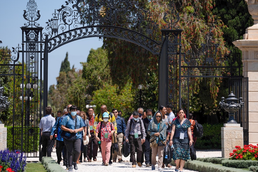 Un groupe de délégués entre par la porte Collins et s’approche du tombeau de Bahá’u’lláh.