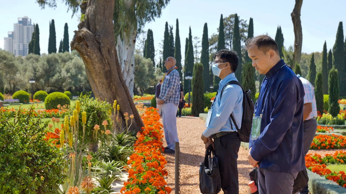 Delegates outside the Shrine of Bahá'u'lláh praying and meditating.