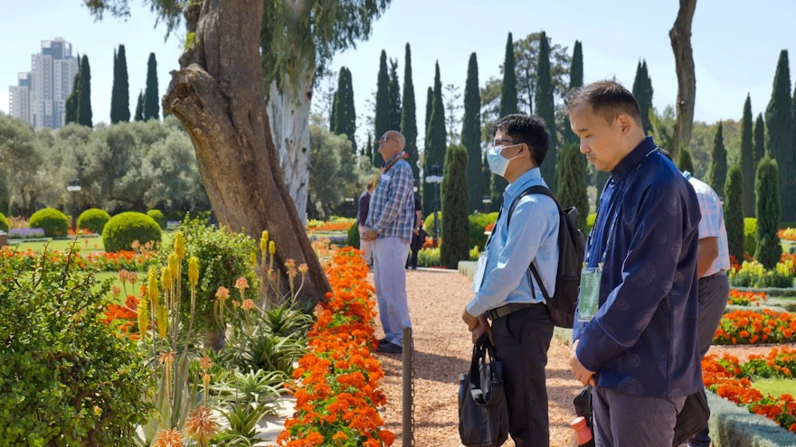 Délégués à l’extérieur du tombeau de Bahá’u’lláh en train de prier et méditer.