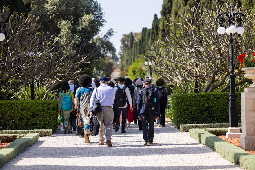 Délégués approchant le long d’un sentier pour visiter le tombeau de Bahá’u’lláh.