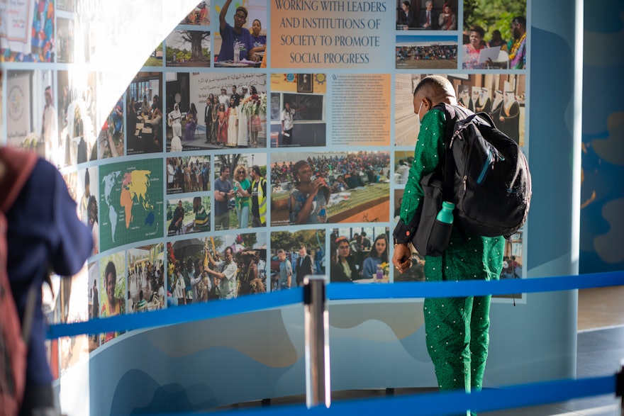 Un délégué regardant une partie de l’exposition sur les efforts bahá’ís en faveur du progrès social.