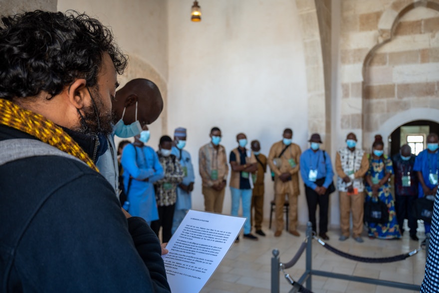 A delegate reads a passage from the Bahá’í writings during the visit to the Prison Cell.