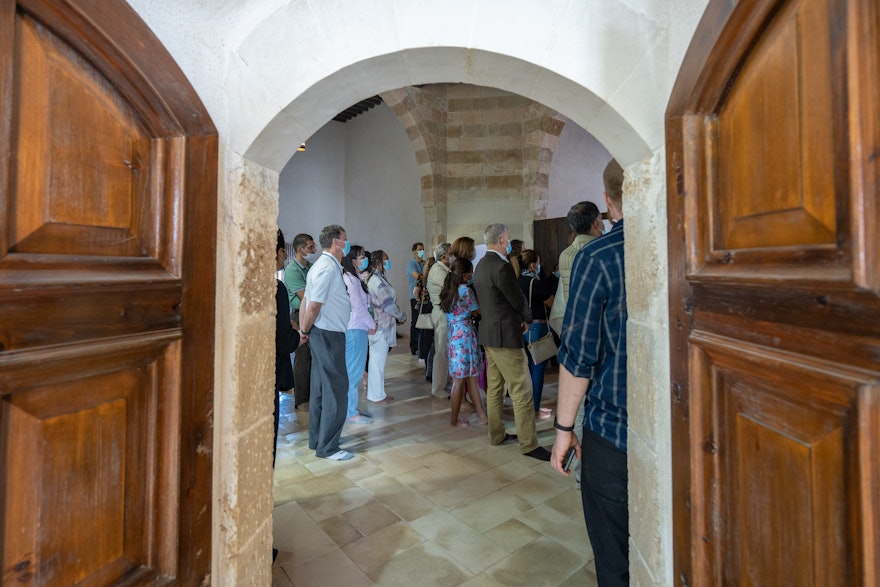 A group of delegates visiting the prison, seen through the doors of one of the cells.