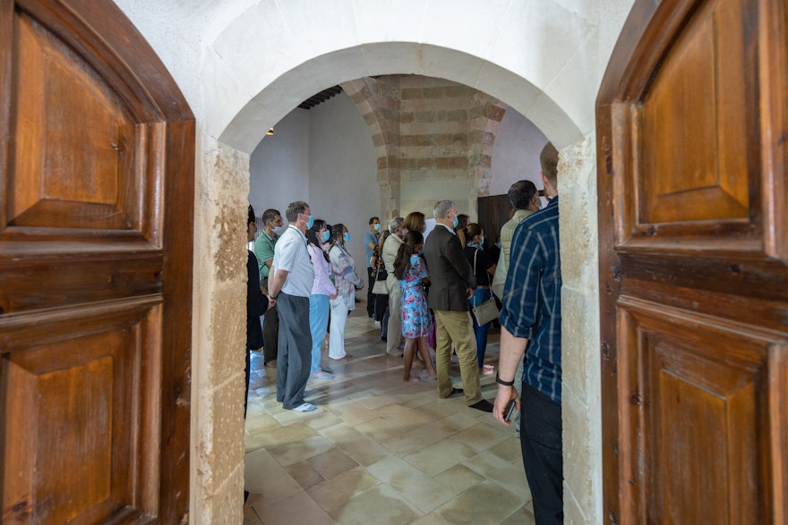 Un groupe de délégués visitant la prison, vu à travers les portes d’une des cellules.