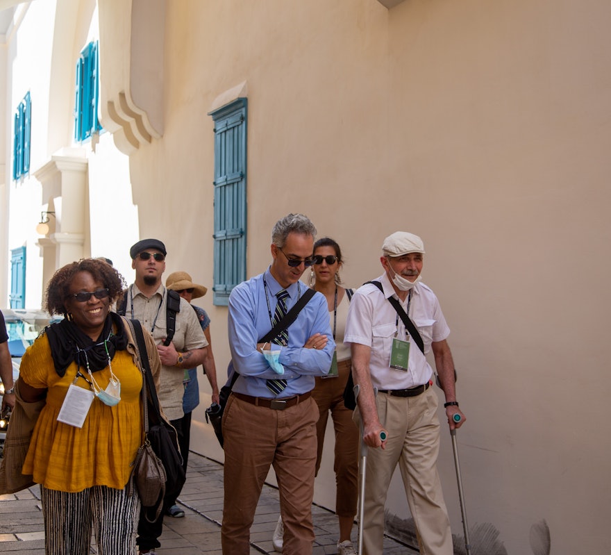 Un groupe de participants à la Convention passe par la ruelle à côté de la maison de ‘Abbúd.